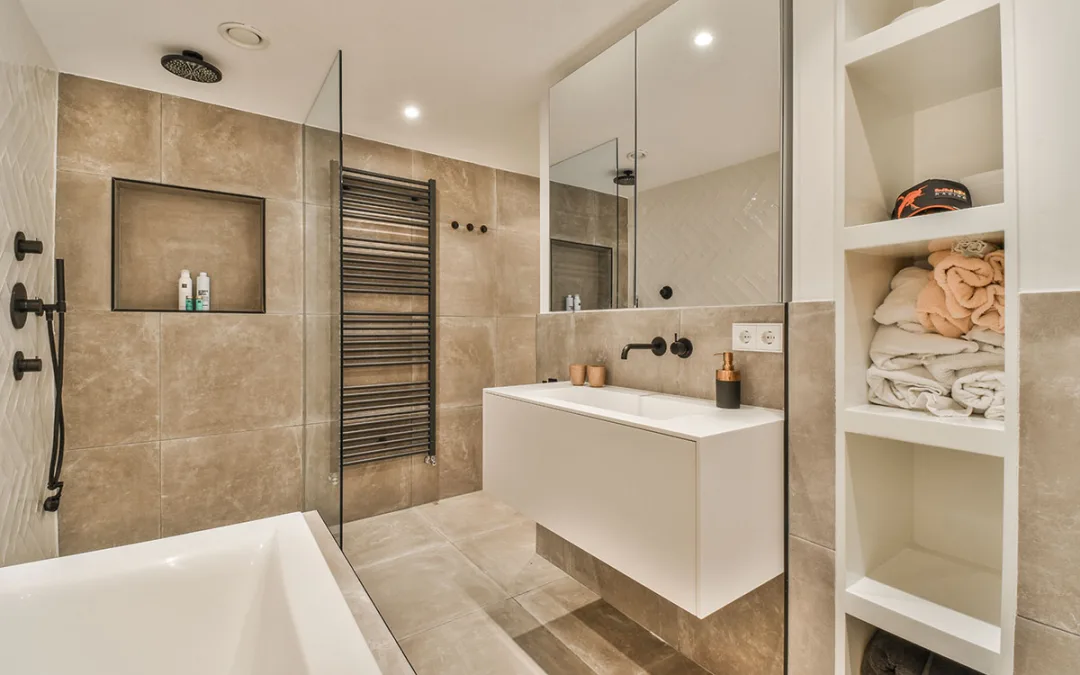 modern bathroom with beige tiles and white fixtures on the walls, along with a glass shower stall in the corner